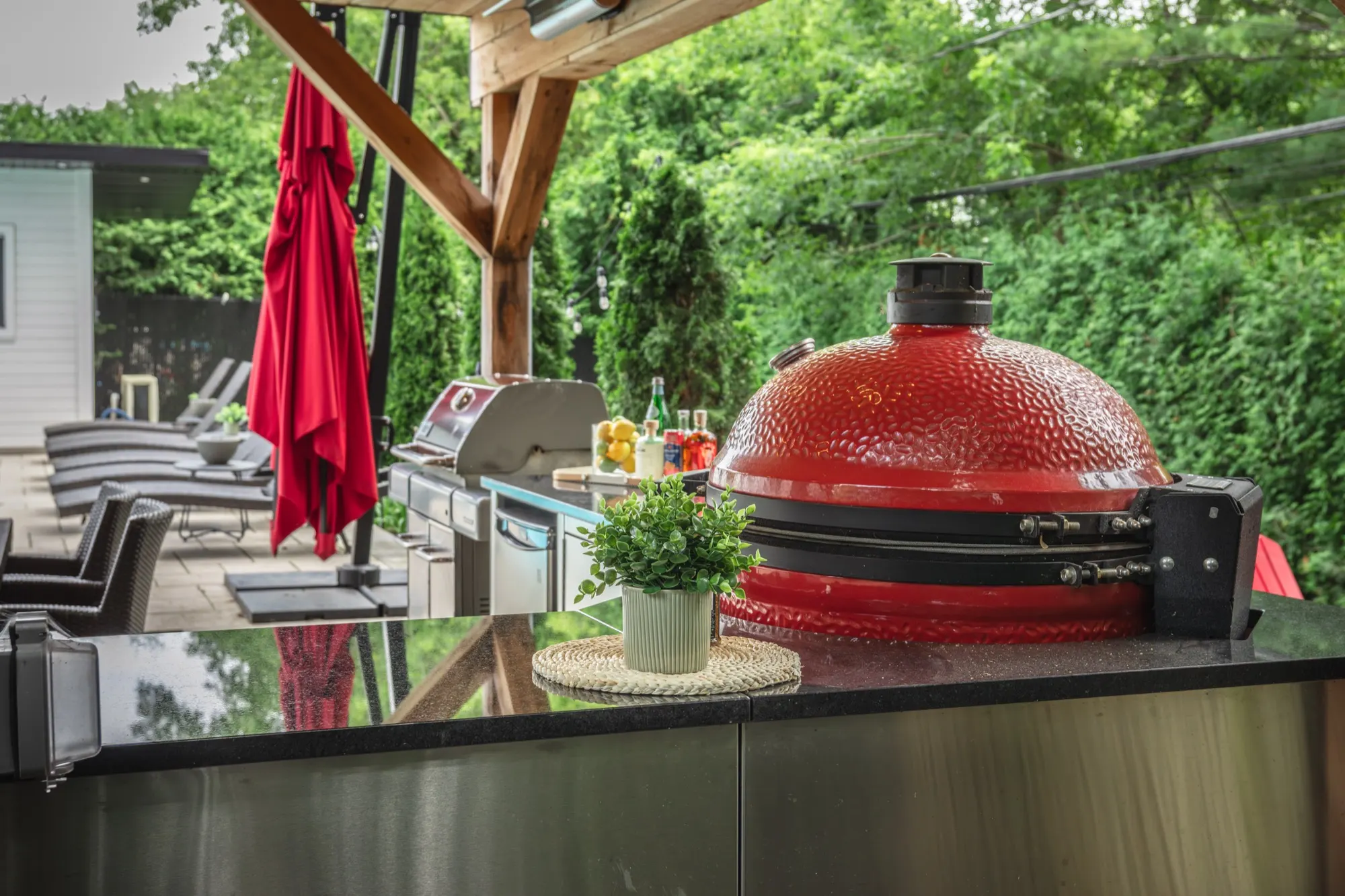 Comptoir d'inox et kamado sous les arbres