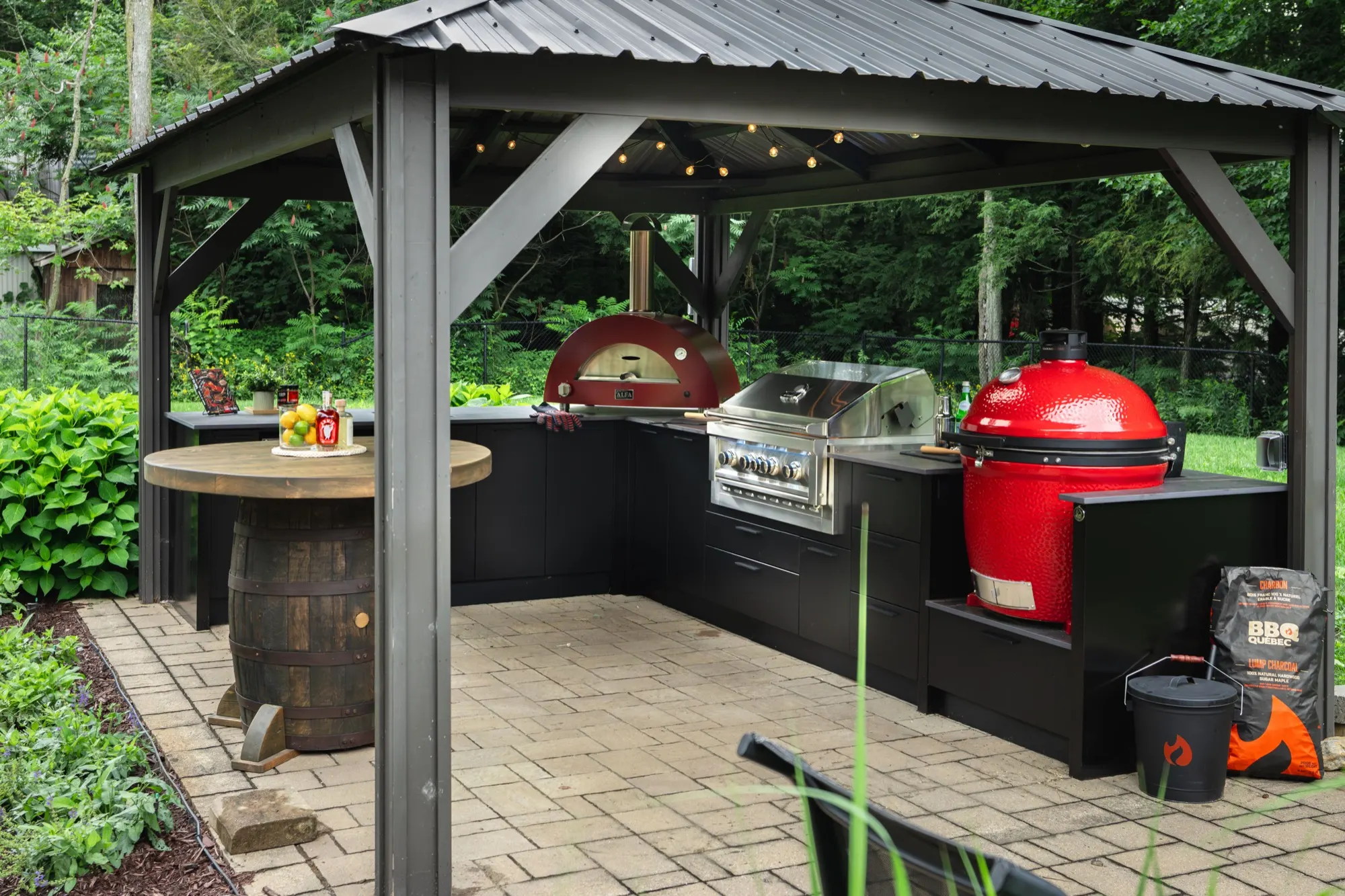 Gazebo avec cuisine extérieure noire, kamado et four à pizza