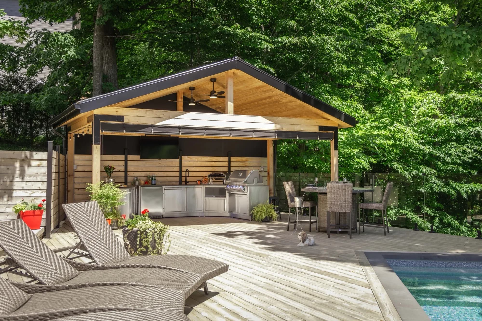 Cuisine extérieure en inox sous une toiture de bois à Saint-Sauveur