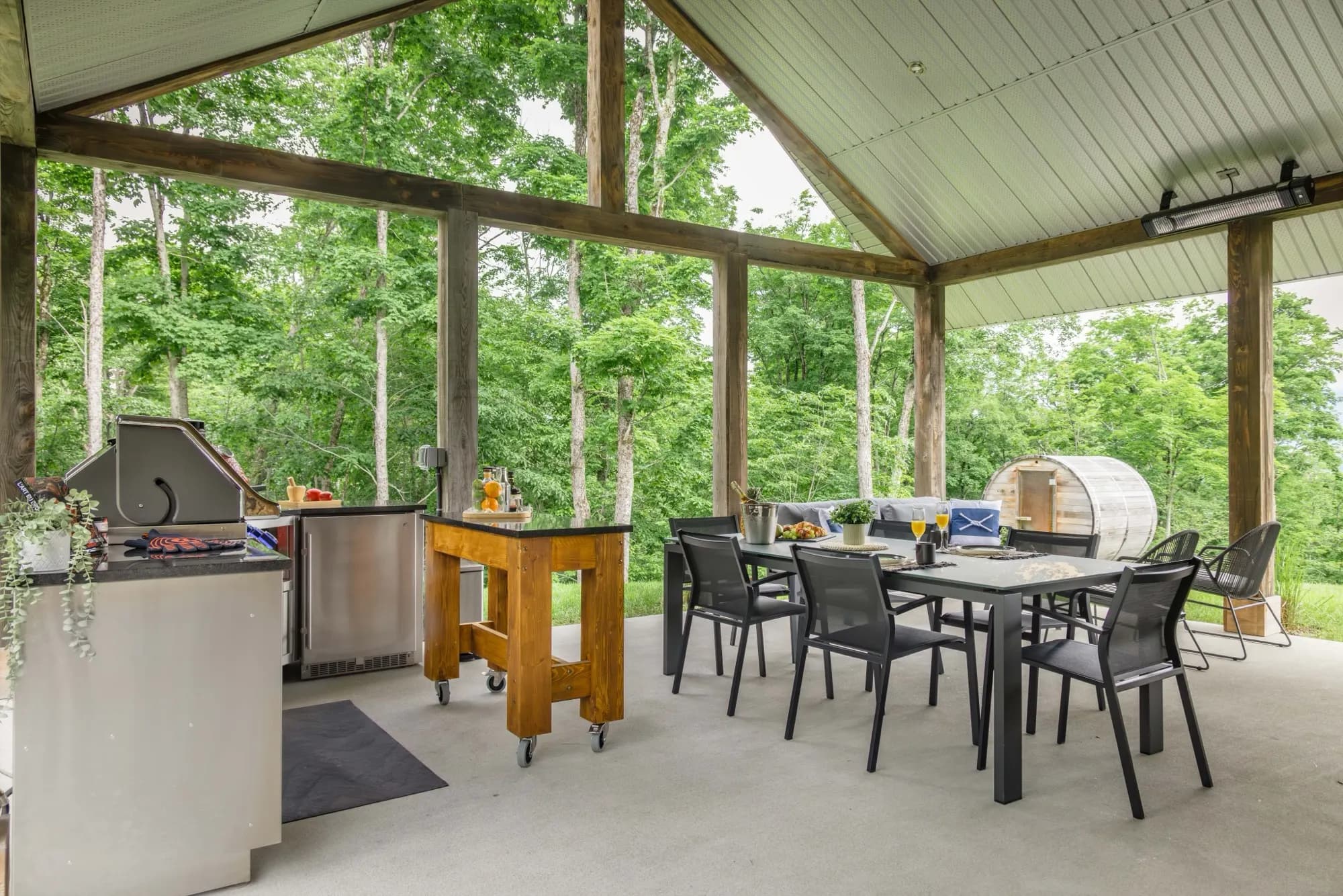 Pavillon de bois avec cuisine extérieure en inox et kamado rouge à Mont-Tremblant